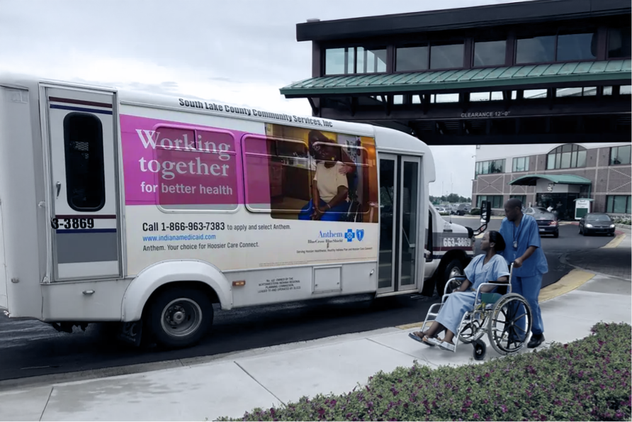 Bus with healthcare advertisement parked at a transit stop